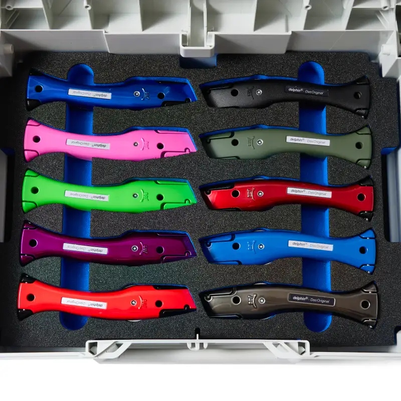 Colourful Janser Premium Dolphin knives arranged in a fitted presentation case.