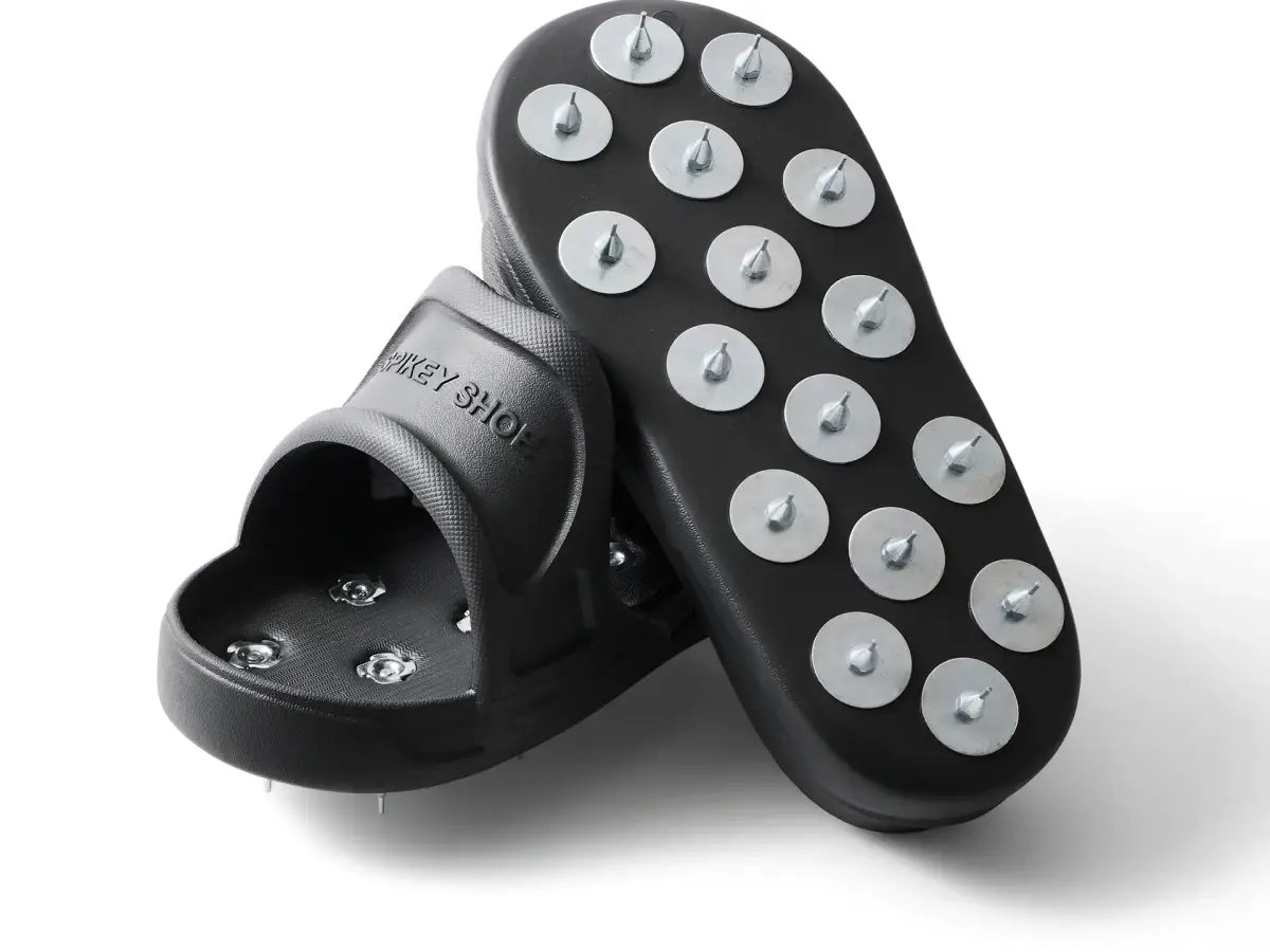 Pair of black Kevmor Spikey flooring shoes showing the metal-spiked soles on a white background