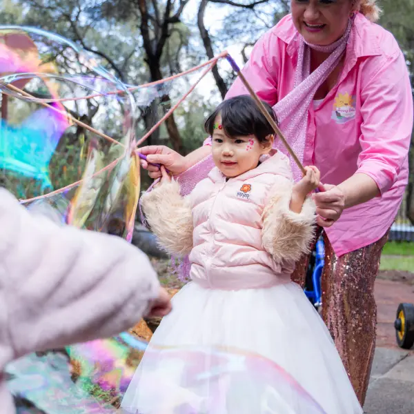 Child enjoying giant-bubble entertainment during a Perth birthday party.