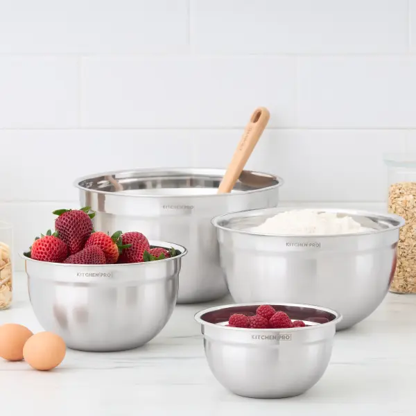 KitchenPro stainless-steel mixing bowls styled with strawberries, flour and baking ingredients.