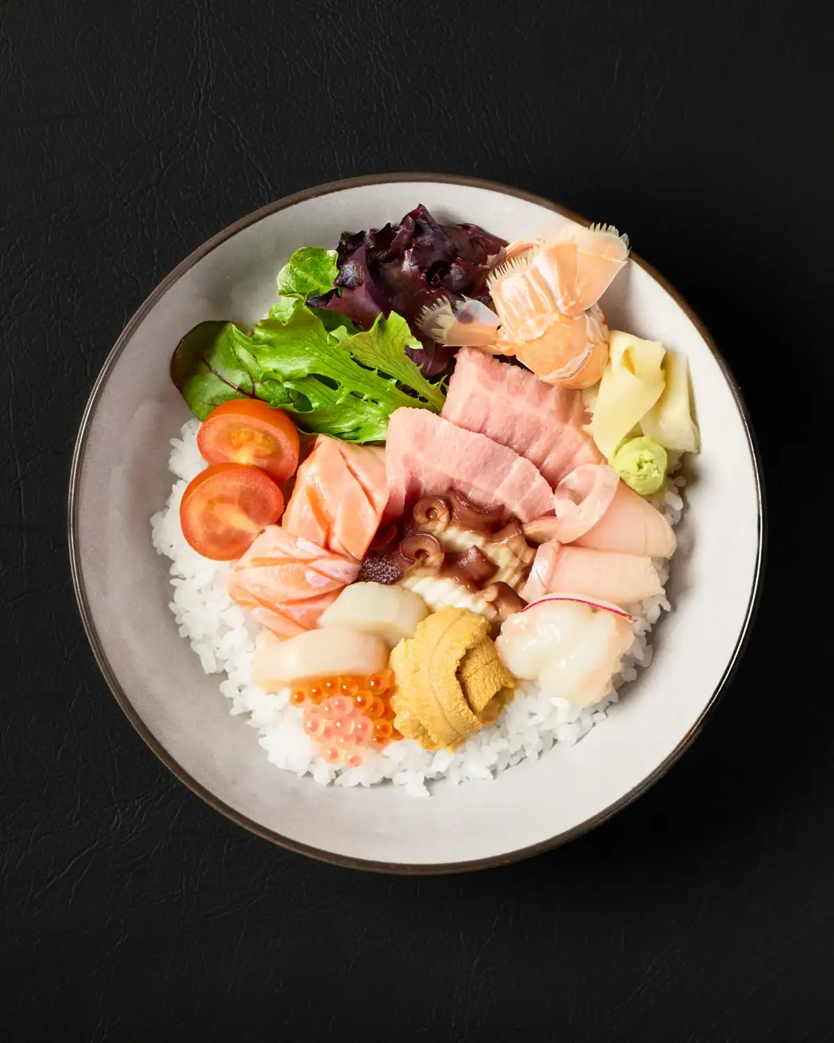 Mixed sashimi rice bowl with greens and garnishes at Kuza Urban Japanese Food.