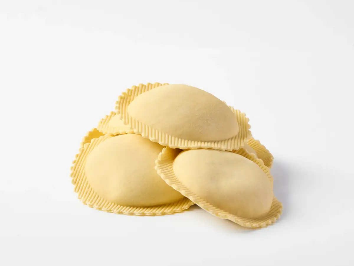 Fresh La Delizia Lab lobster and prawn agnolotti stacked and photographed on a clean white background
