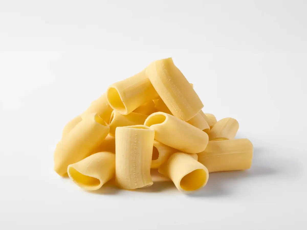 A pile of fresh La Delizia Lab paccheri tubes photographed on a clean white background