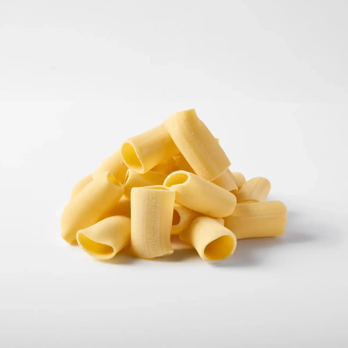 A pile of fresh La Delizia Lab paccheri tubes photographed on a clean white background