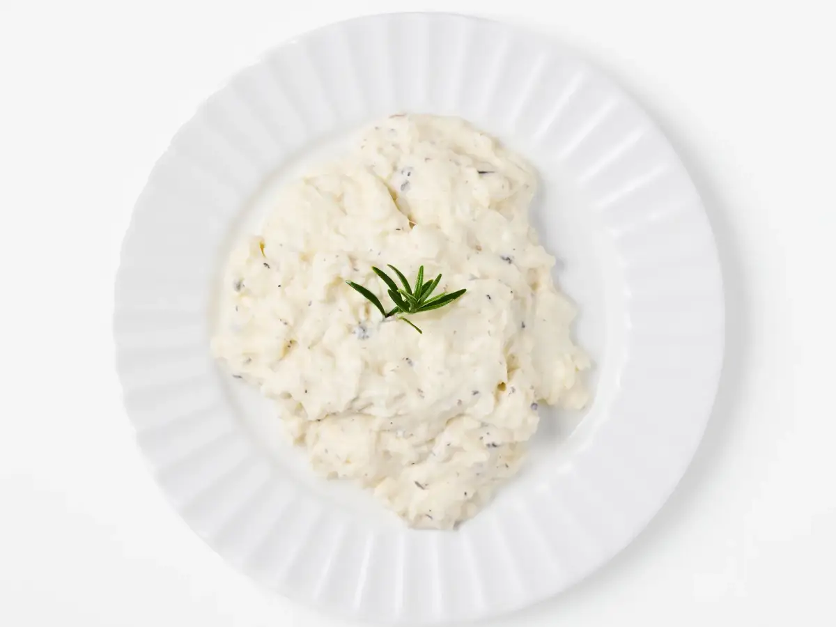 La Delizia Latticini truffle stracciatella served on a white fluted plate with a sprig of rosemary, photographed from above