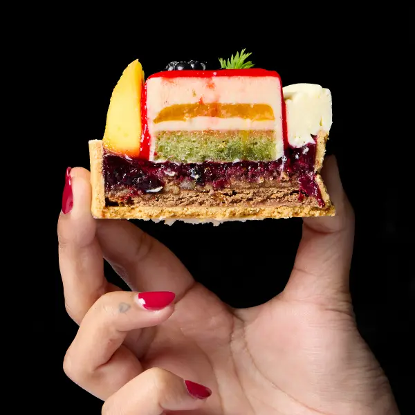 Layered pastry slice held in hand for Perth food photography.