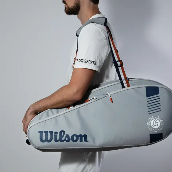 Model carrying a tennis bag during an outdoor lifestyle product session.
