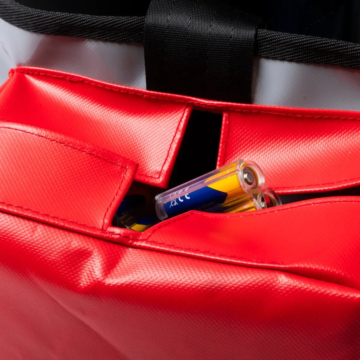 Close-up of the red battery pocket on a Lubie SPL 250 maintenance bag showing separate battery storage