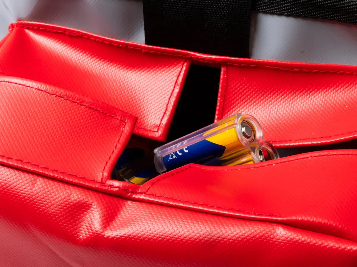 Close-up of the red battery pocket on a Lubie SPL 250 maintenance bag showing separate battery storage