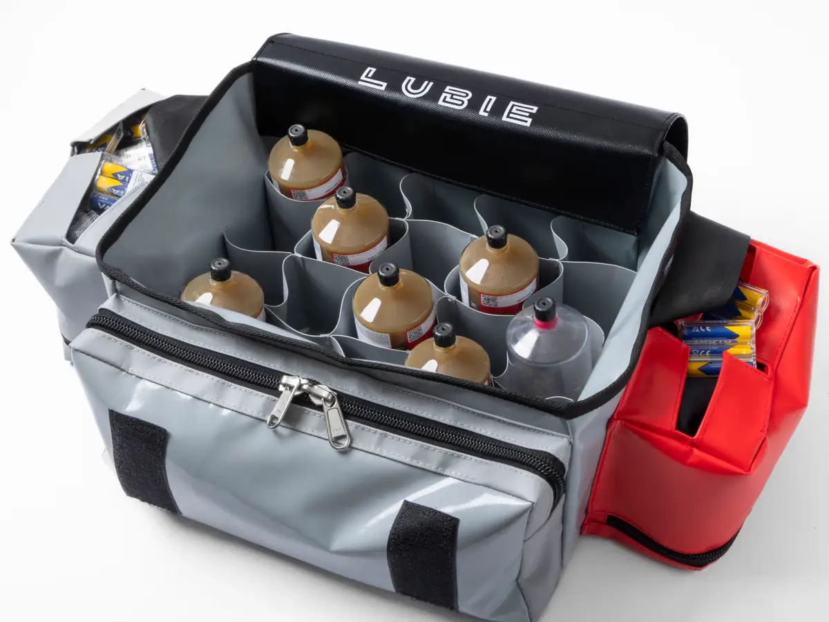 Open Lubie SPL 250 maintenance bag loaded with lubricant cartridges and batteries in dedicated compartments