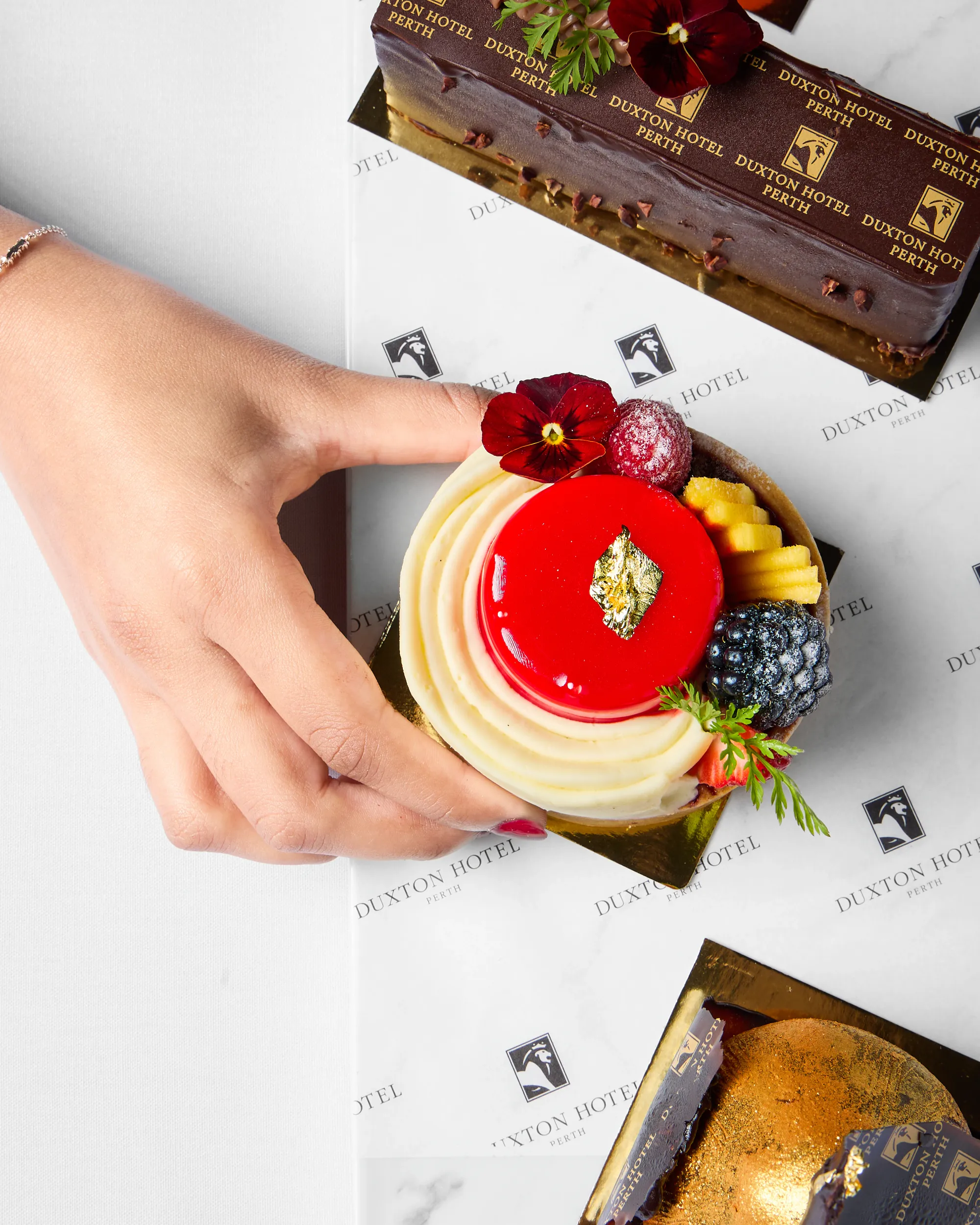Luxury pastry box with berries and a red glazed dessert