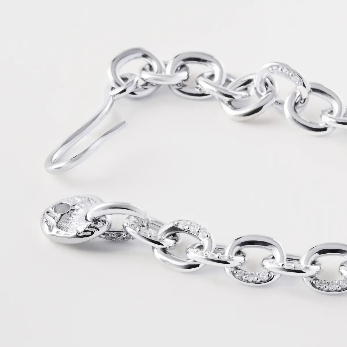 Close-up of a silver diamond-link bracelet showing polished links and clasp construction.