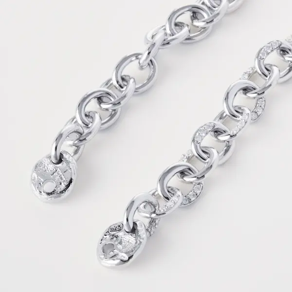Layered silver chain bracelets photographed together to show scale and link variation.