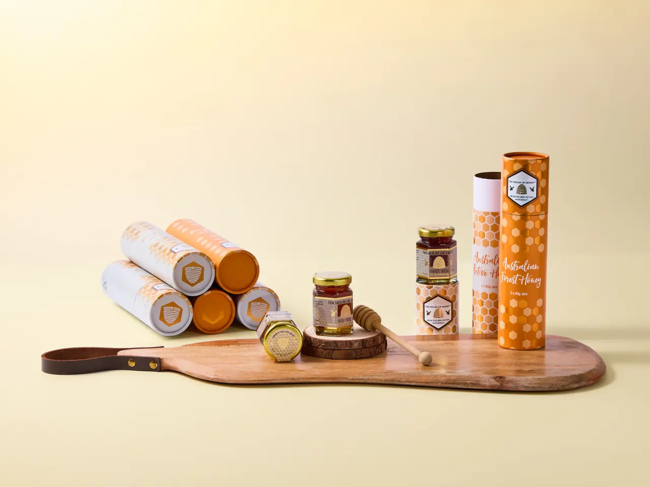 House of Honey gift tubes and jars styled on a warm yellow set for branded product photography in Perth.