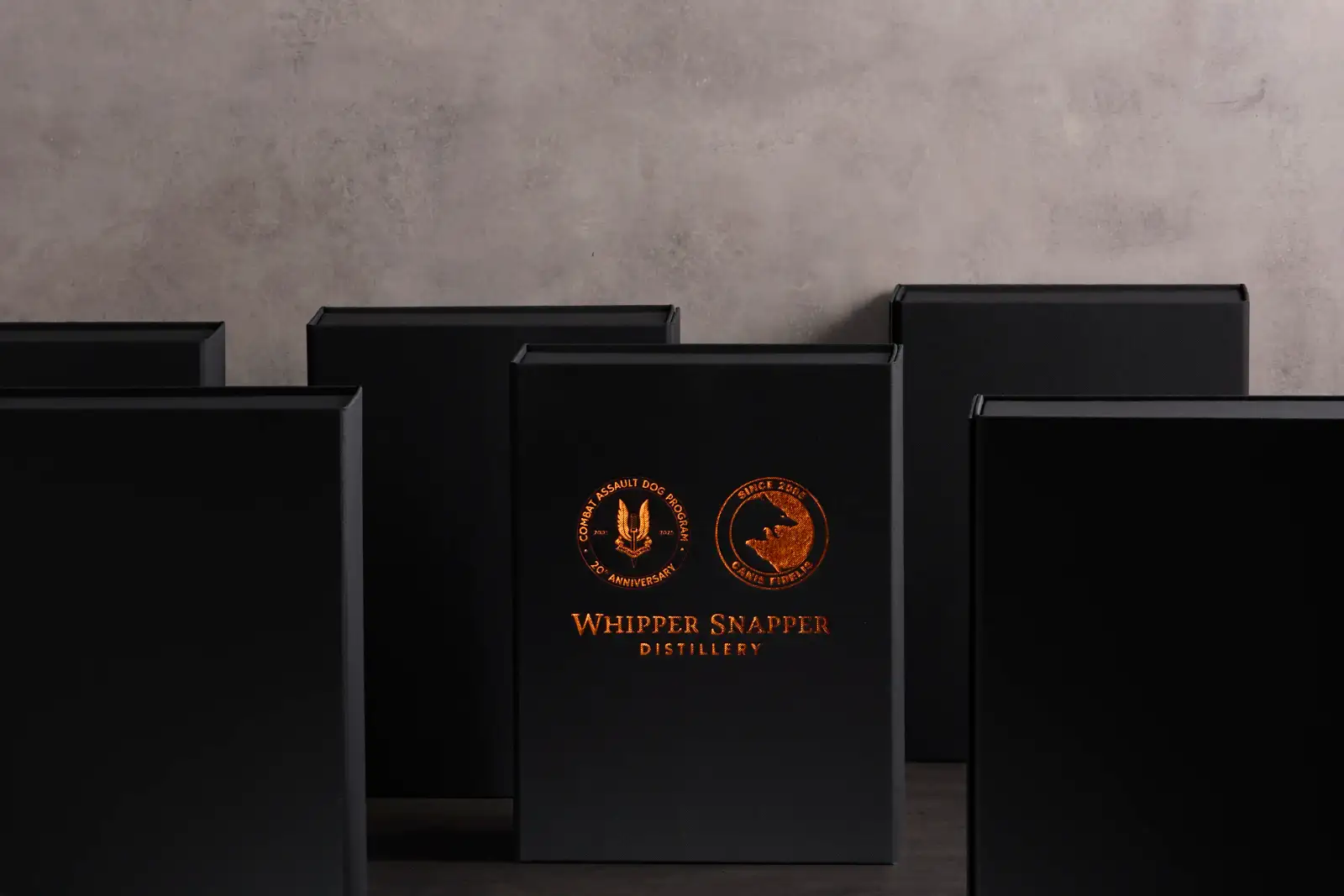 Black premium packaging boxes with copper foil Whipper Snapper Distillery branding arranged on a dark studio set by Myerton Packaging