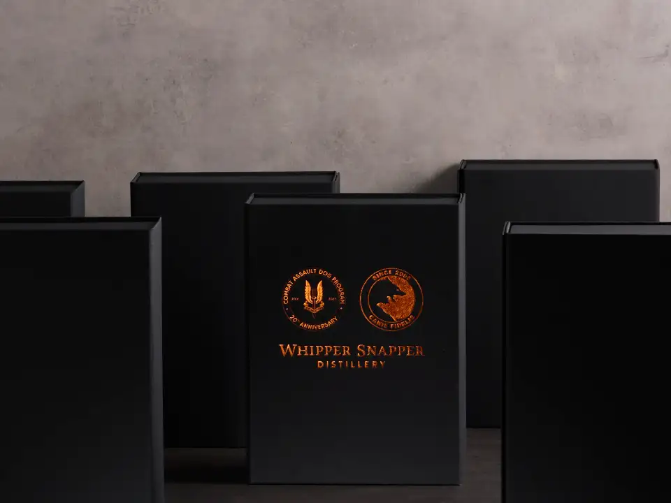 Black premium packaging boxes with copper foil Whipper Snapper Distillery branding arranged on a dark studio set by Myerton Packaging