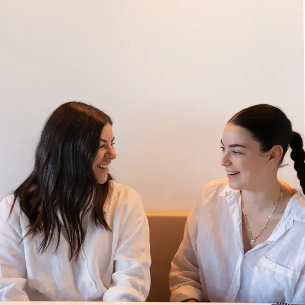 Two women sharing a natural expression during a relaxed portrait session.