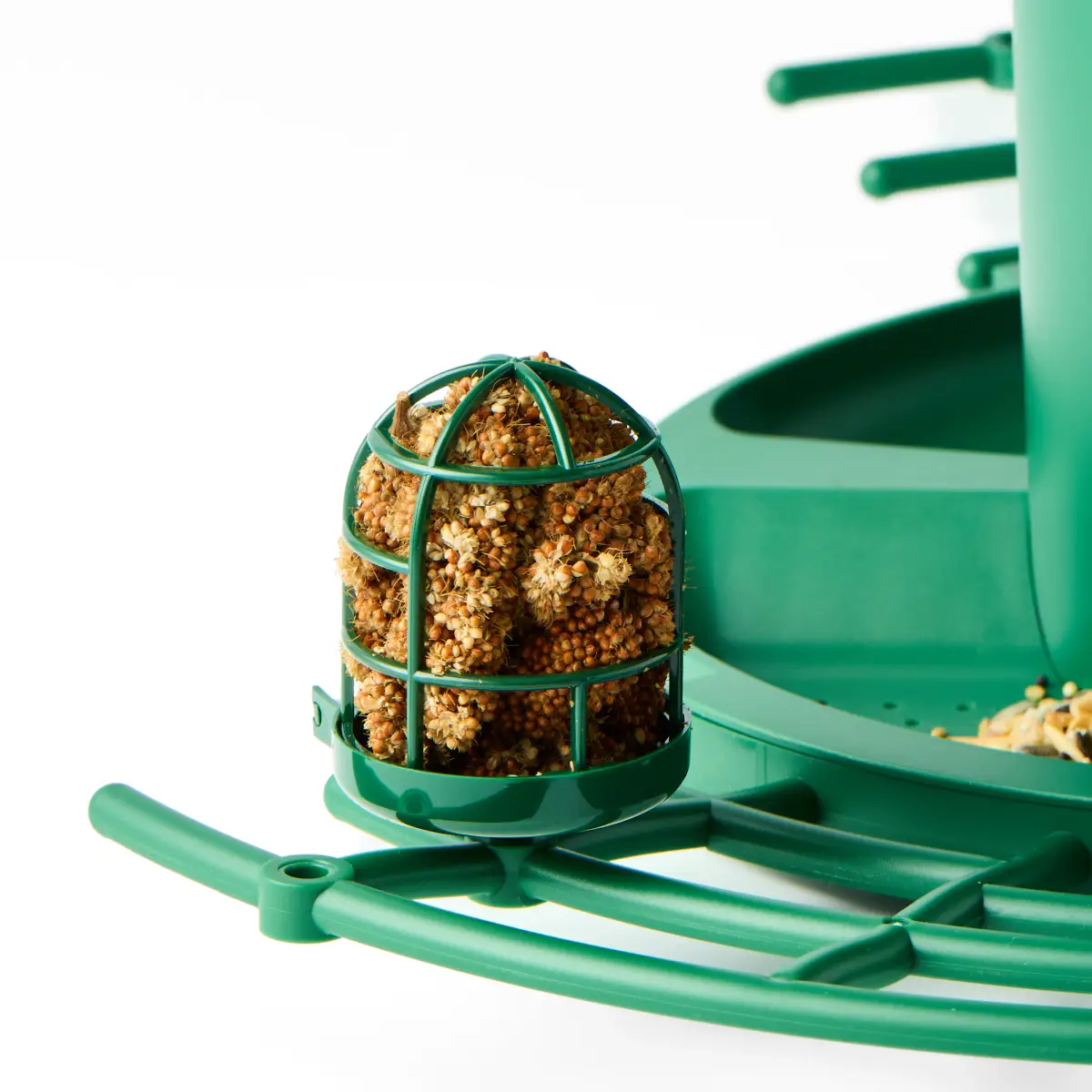 Green wire feeding attachment holding a seed ball beside the Nexavian bird feeder platform