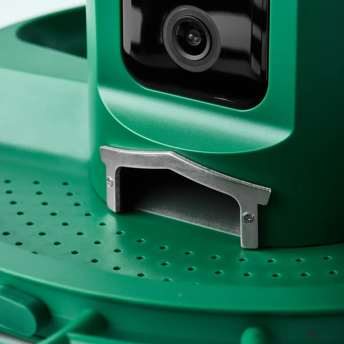 Close-up of the seed outlet and perforated green feeding tray below the Nexavian bird feeder camera