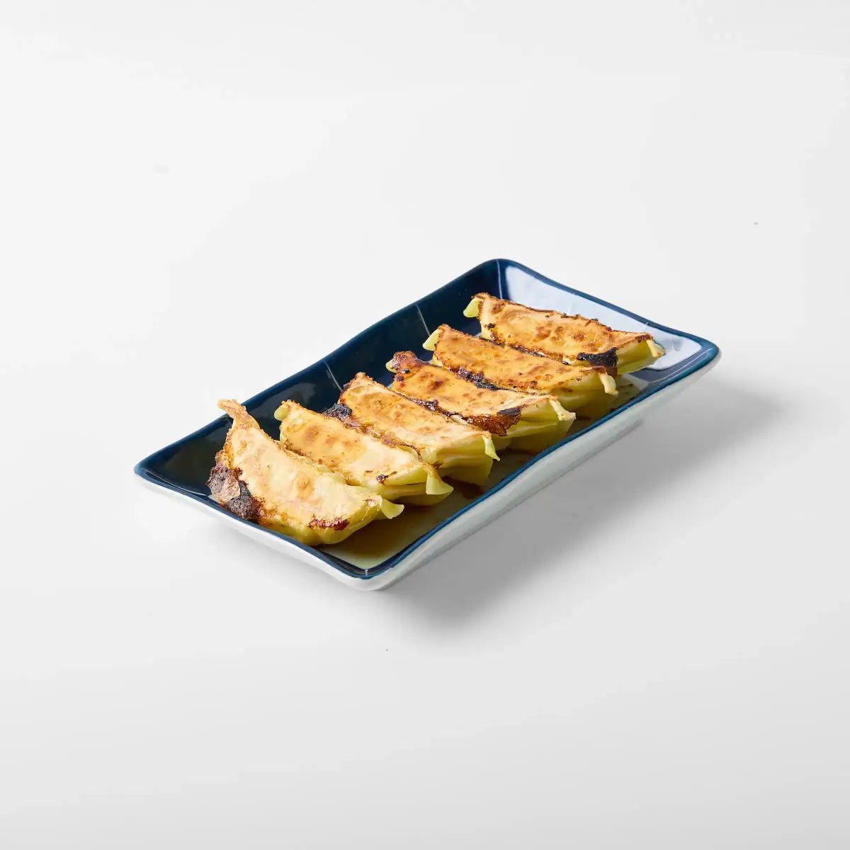 Close-up menu photo of Omasa Japanese Restaurant chicken gyoza on a blue rectangular plate against a white background