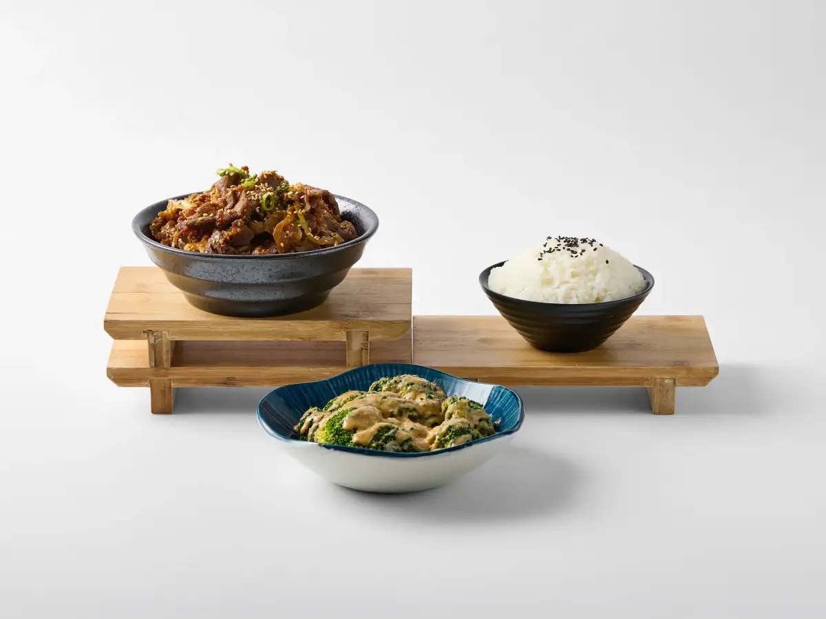 White-background menu spread for Omasa Japanese Restaurant showing a beef donburi bowl with rice, broccoli, and supporting dishes arranged on timber risers