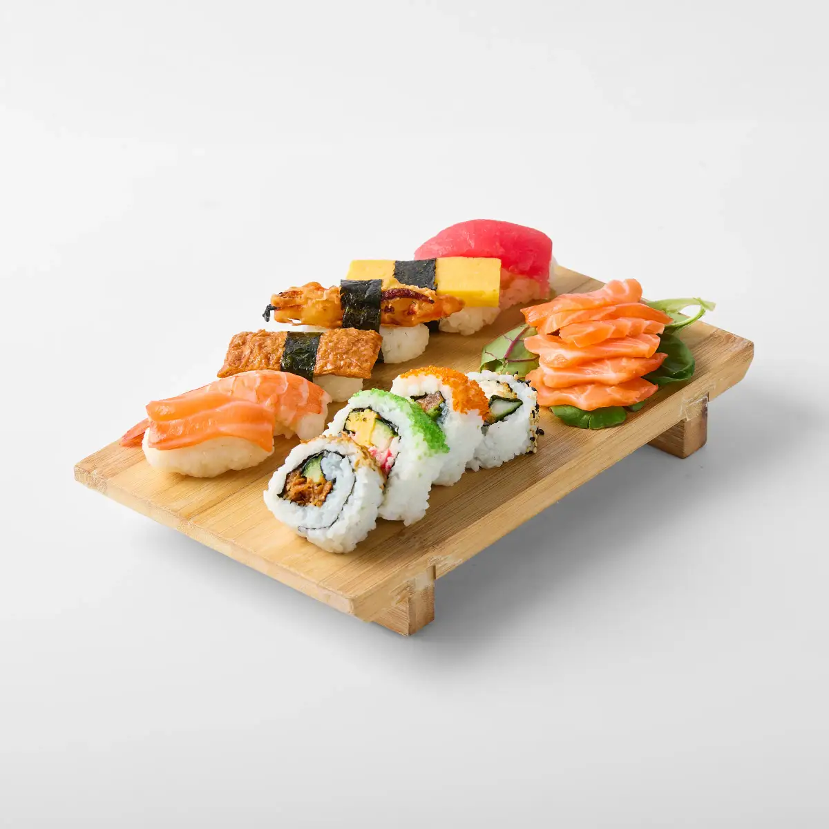 Assorted nigiri, sashimi, and sushi rolls from Omasa Japanese Restaurant arranged on a timber board against a white background