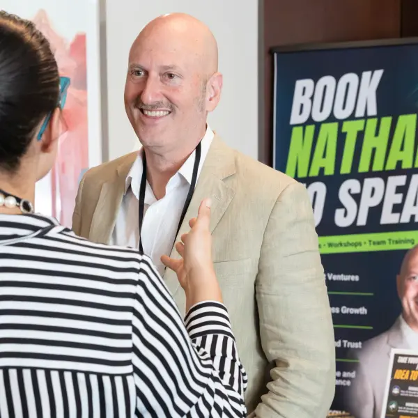 Speaker and delegate networking beside event branding.