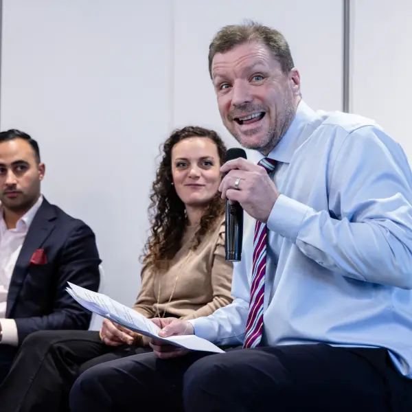 Audience member asking a question during a Perth corporate panel session.