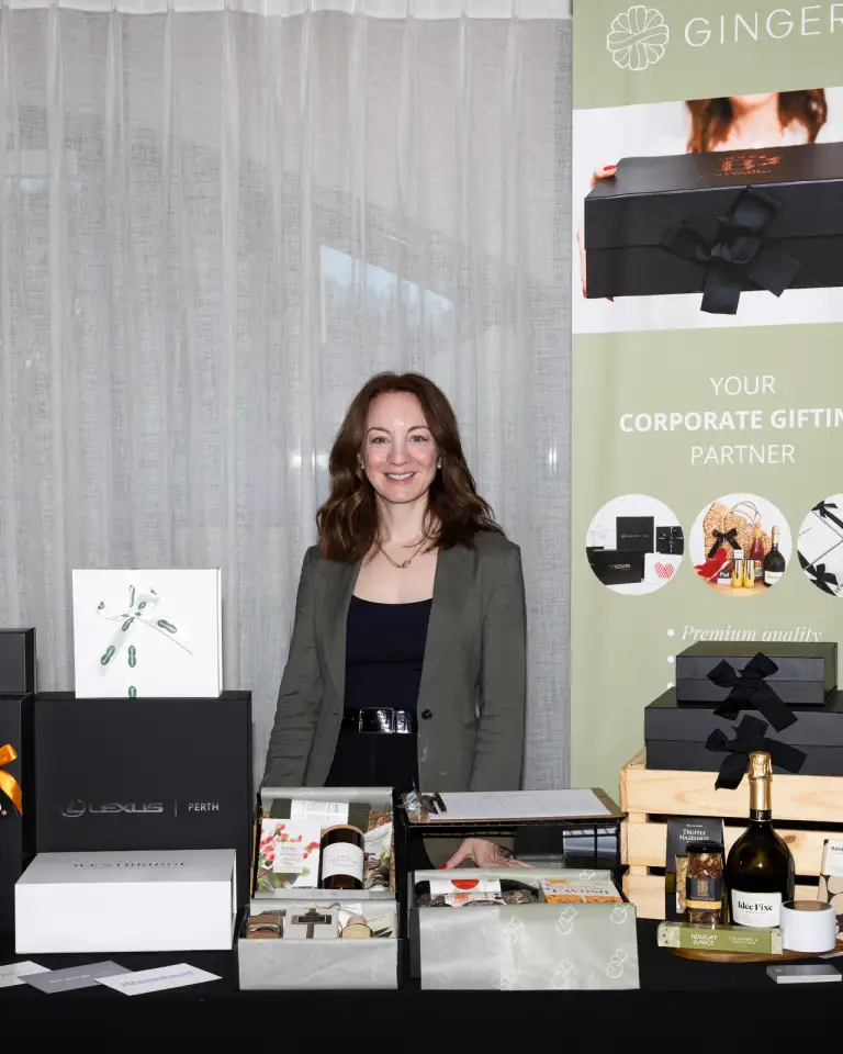 Corporate gifting exhibitor beside a branded trade show display in Perth.