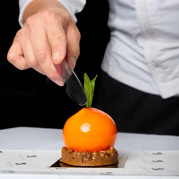 Chef finishing a plated dessert during a Perth hospitality shoot.