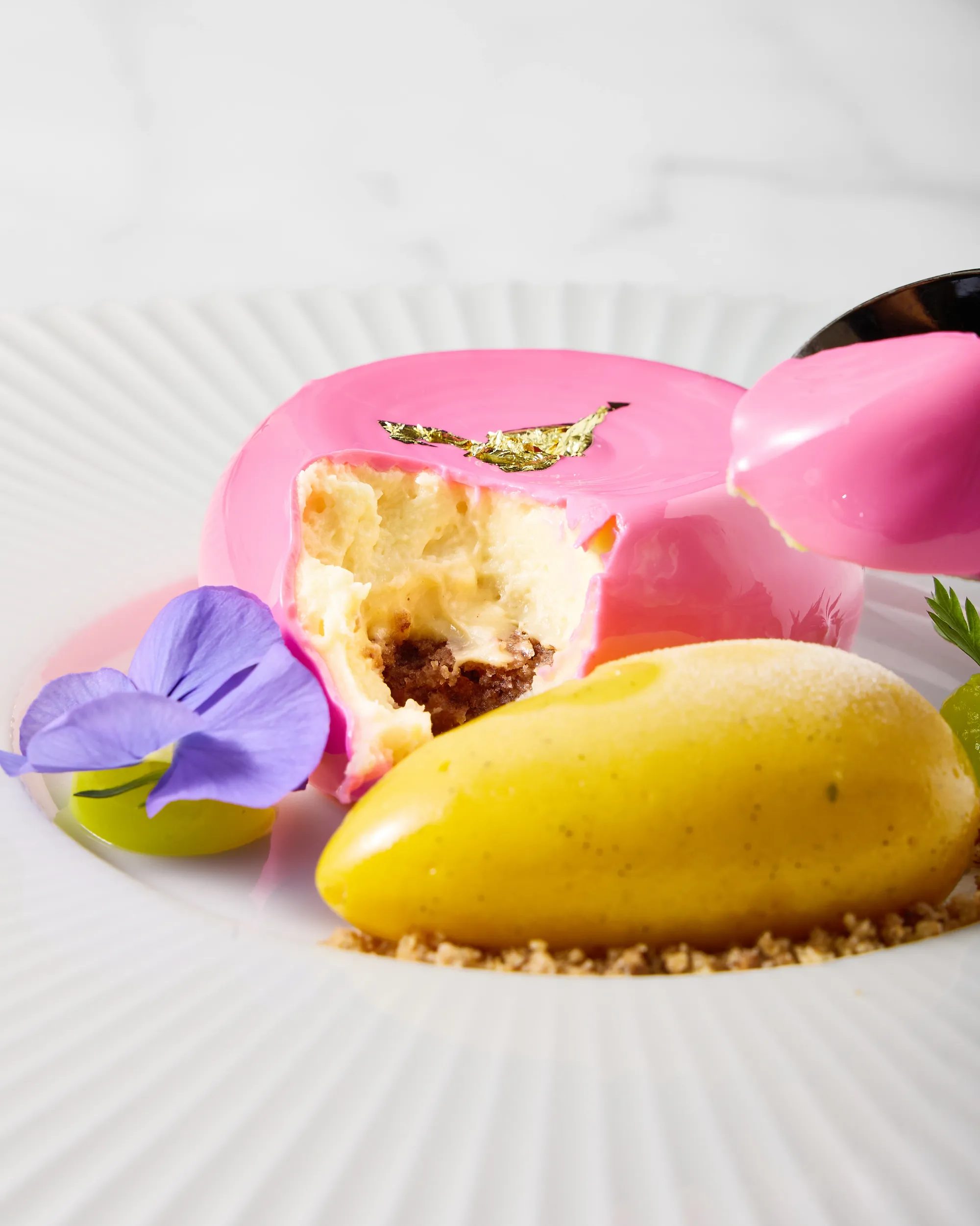 Plated pink dessert with sorbet and edible flower