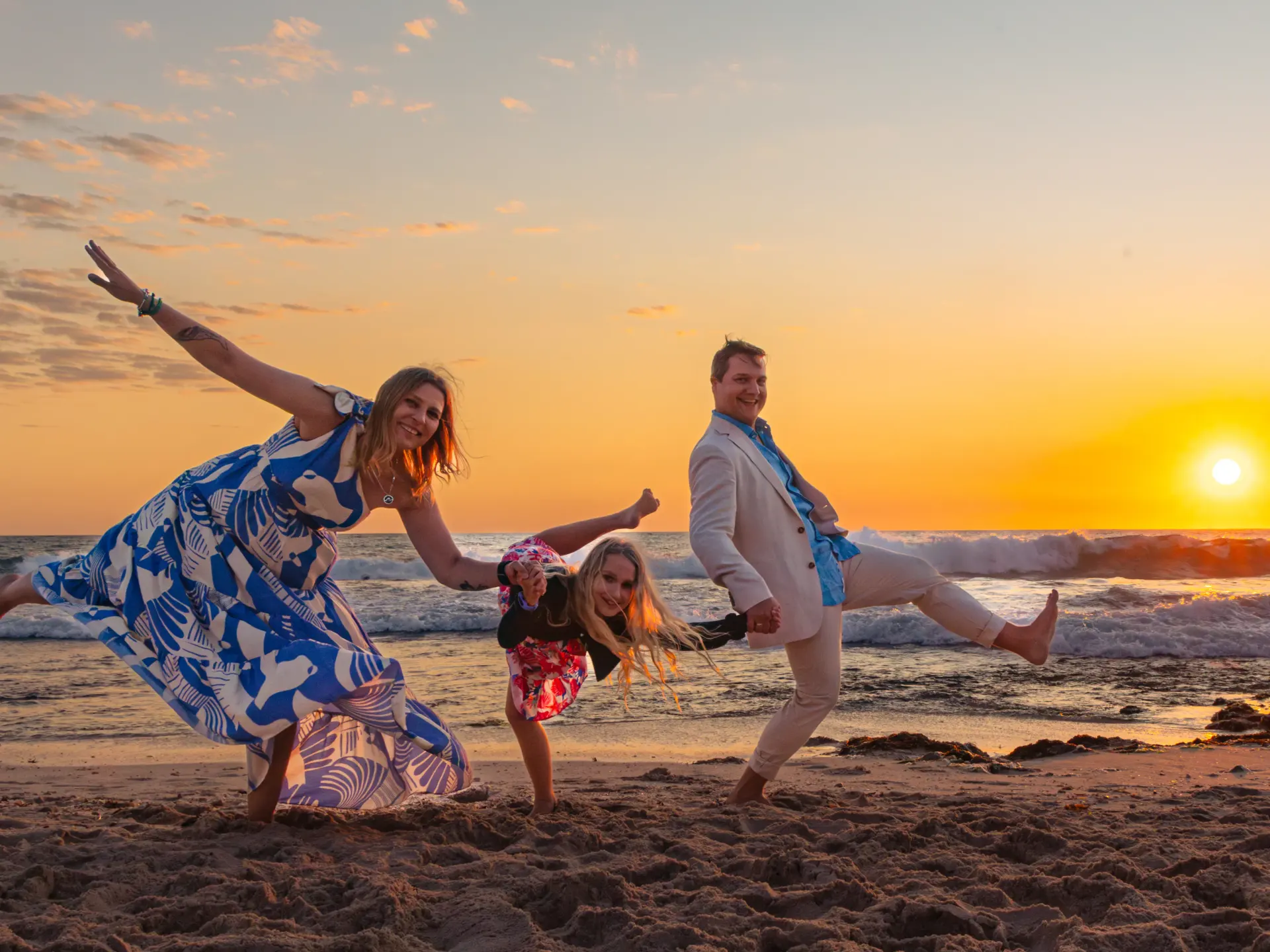 Family sharing a playful candid moment on a Perth beach at sunset.