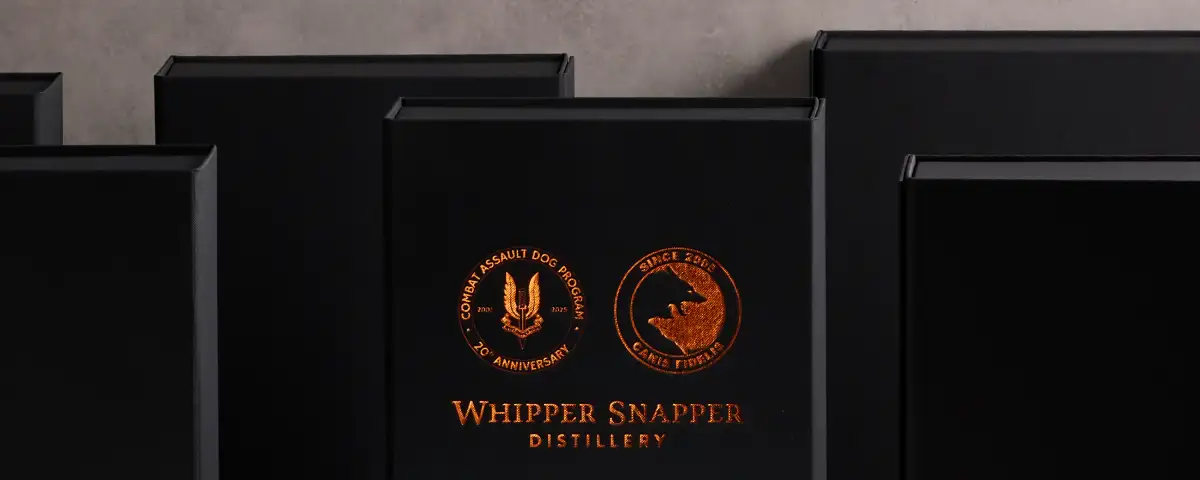 High-end product photography showing black and gold foil packaging for Whipper Snapper Distillery.