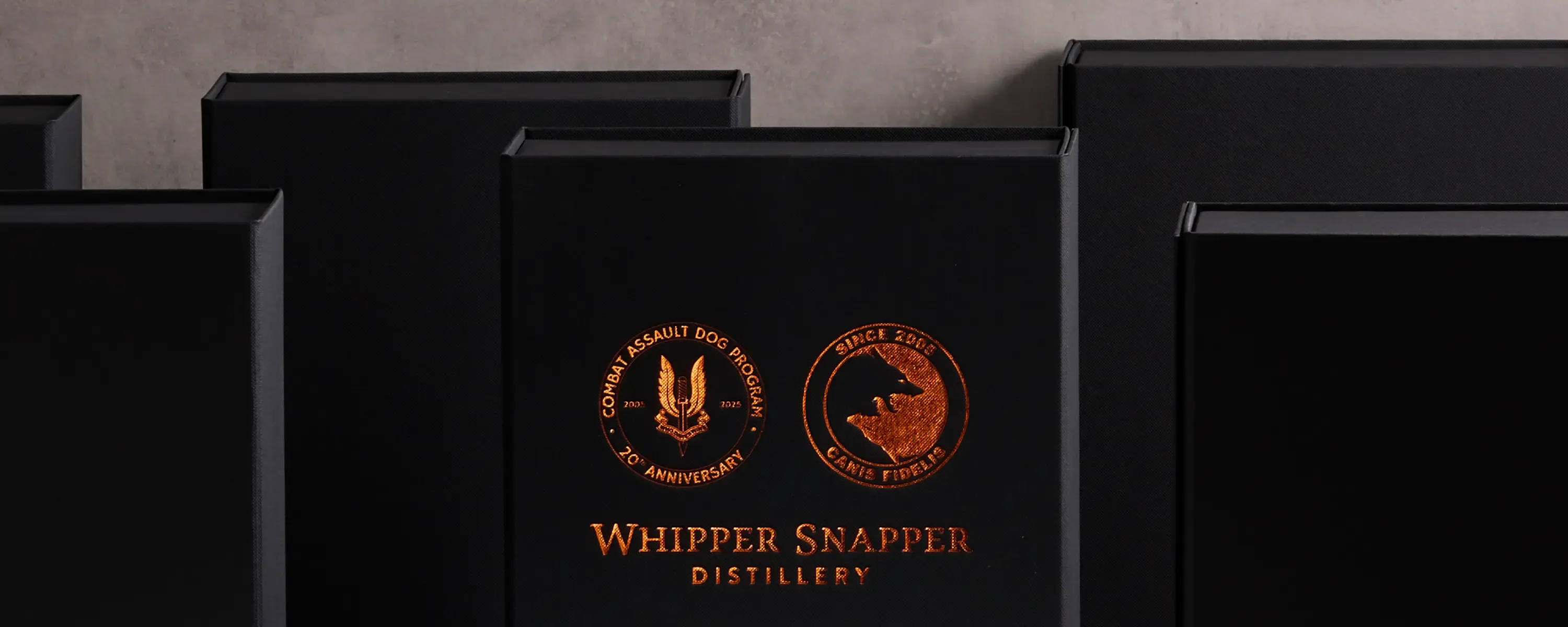 High-end product photography showing black and gold foil packaging for Whipper Snapper Distillery.