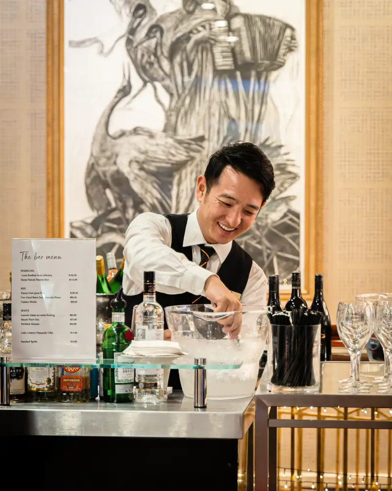 A bartender serving an event bar photographed for catering photography in Perth.