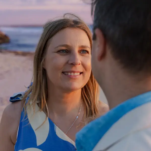 Couple photographed together beside the ocean during a family celebration.