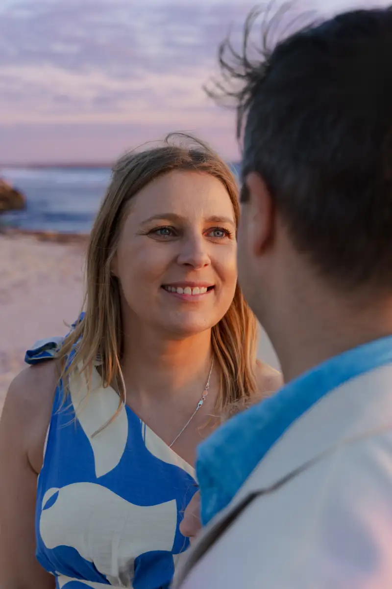 Couple photographed together beside the ocean during a family celebration.