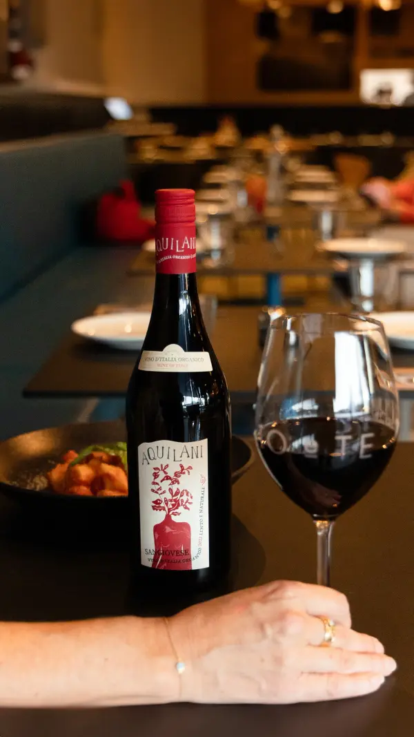 Sangiovese wine bottle and glass at a Perth restaurant, wine and food pairing photography by Amplify.