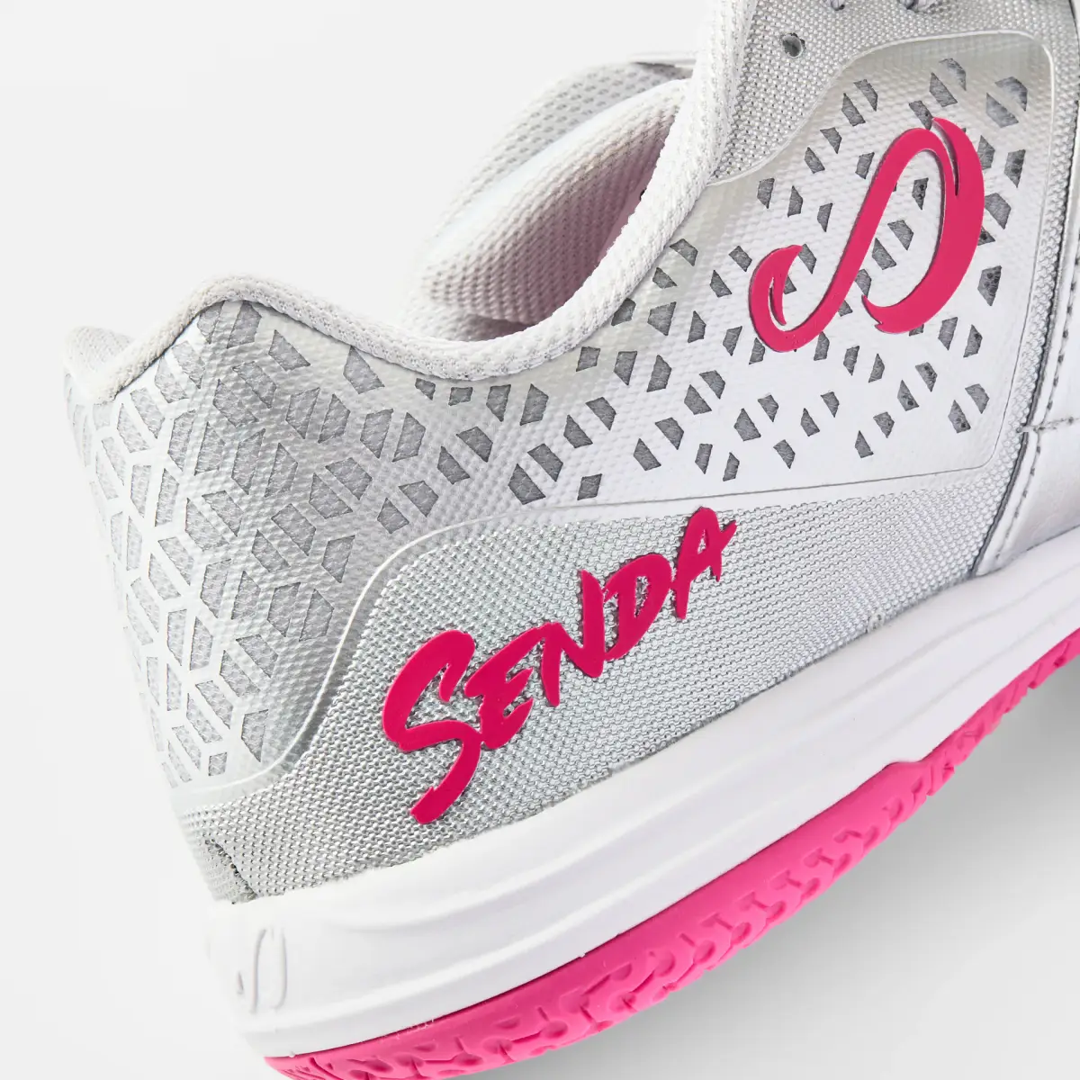 Close-up of the silver and pink Senda Ushuaia futsal shoe showing the perforated upper, side logo, and textured materials