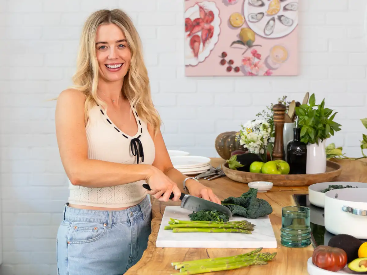 Personal-branding subject smiling while preparing food in her working environment.