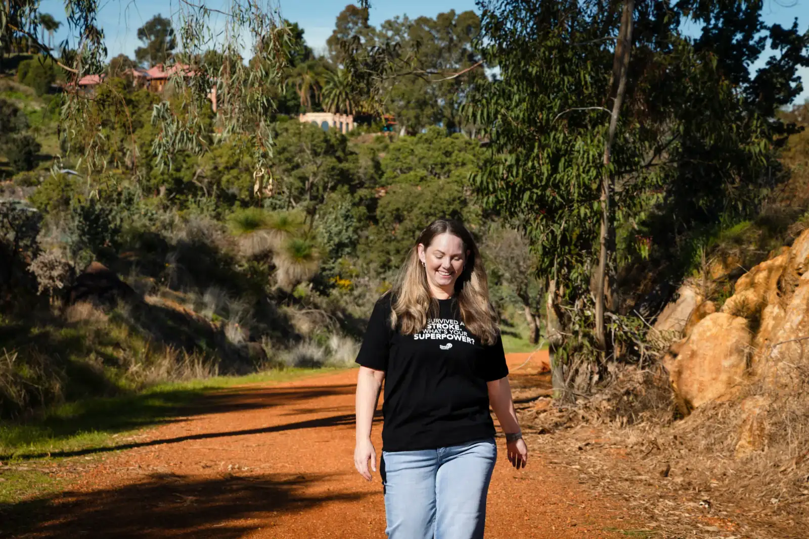 Stroke survivor Karla walking confidently along an Australian bush pathway for the Stroke Foundation appeal campaign
