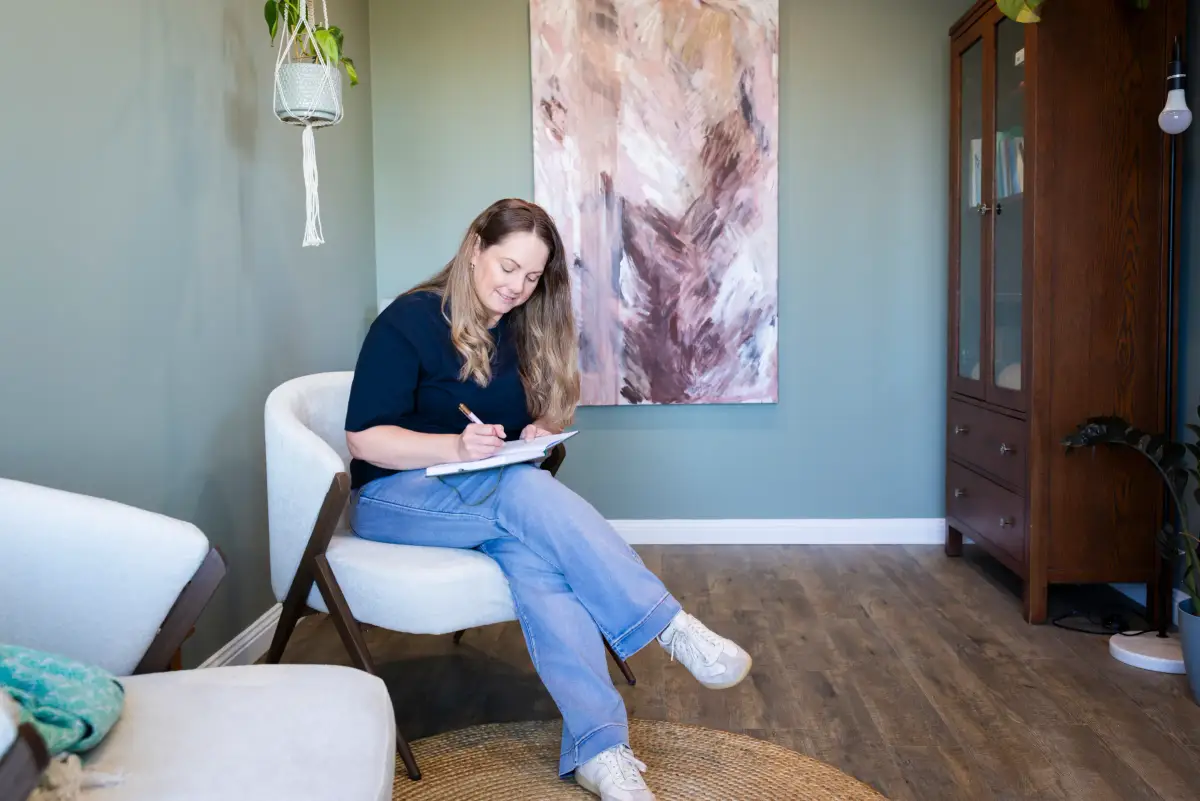 Stroke survivor Karla writing in a journal at home as part of a photography story about recovery after stroke