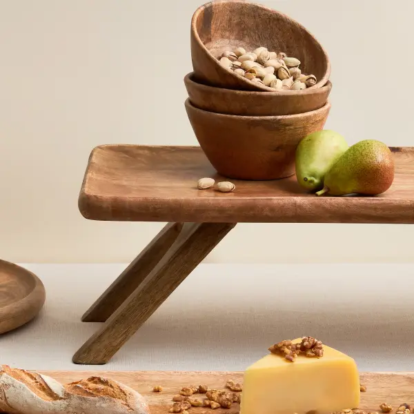 Wooden serving bowls styled in a warm homewares setting.