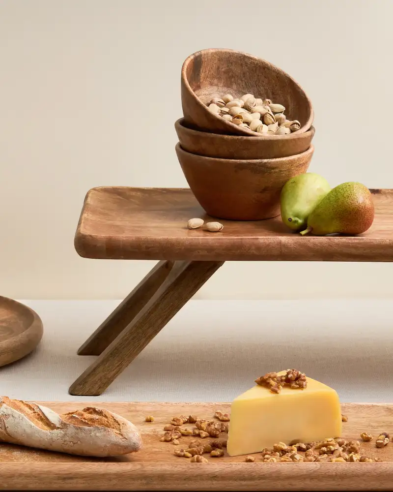 Wooden serving bowls styled in a warm homewares setting.
