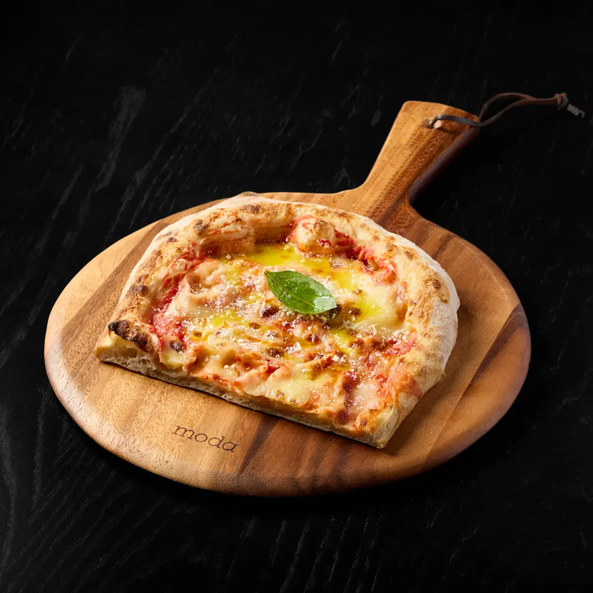 Action cheese pull of a fresh Margherita pizza slice showing crisp charred crust and melted mozzarella at The Good Pizza Myaree