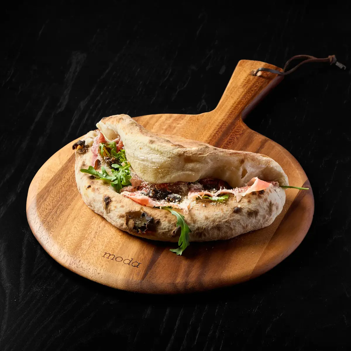 The Truffle Boss gourmet panini cut open with layers of Italian cured meats, melted cheese, and truffle aroma on crusty bread