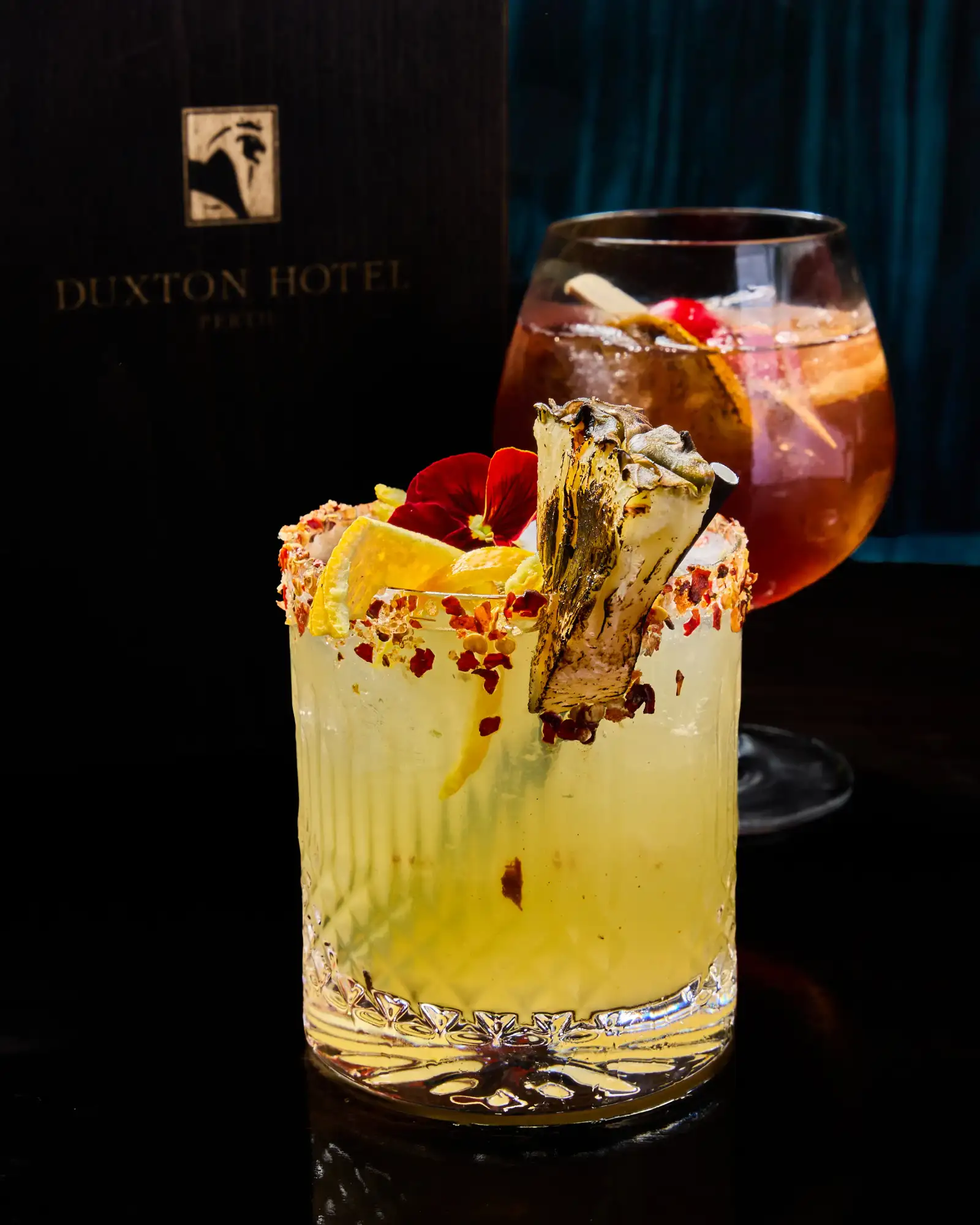 Two signature cocktails photographed for T.O.T.O Bar in Perth CBD with dark bar styling and premium garnish details