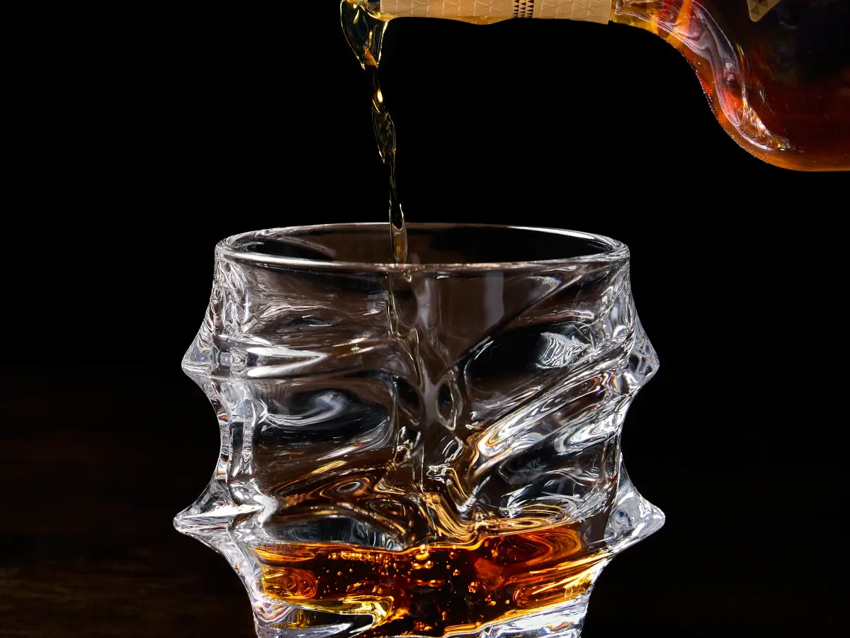 Whisky being poured into a crystal glass for premium drinks photography at T.O.T.O Bar