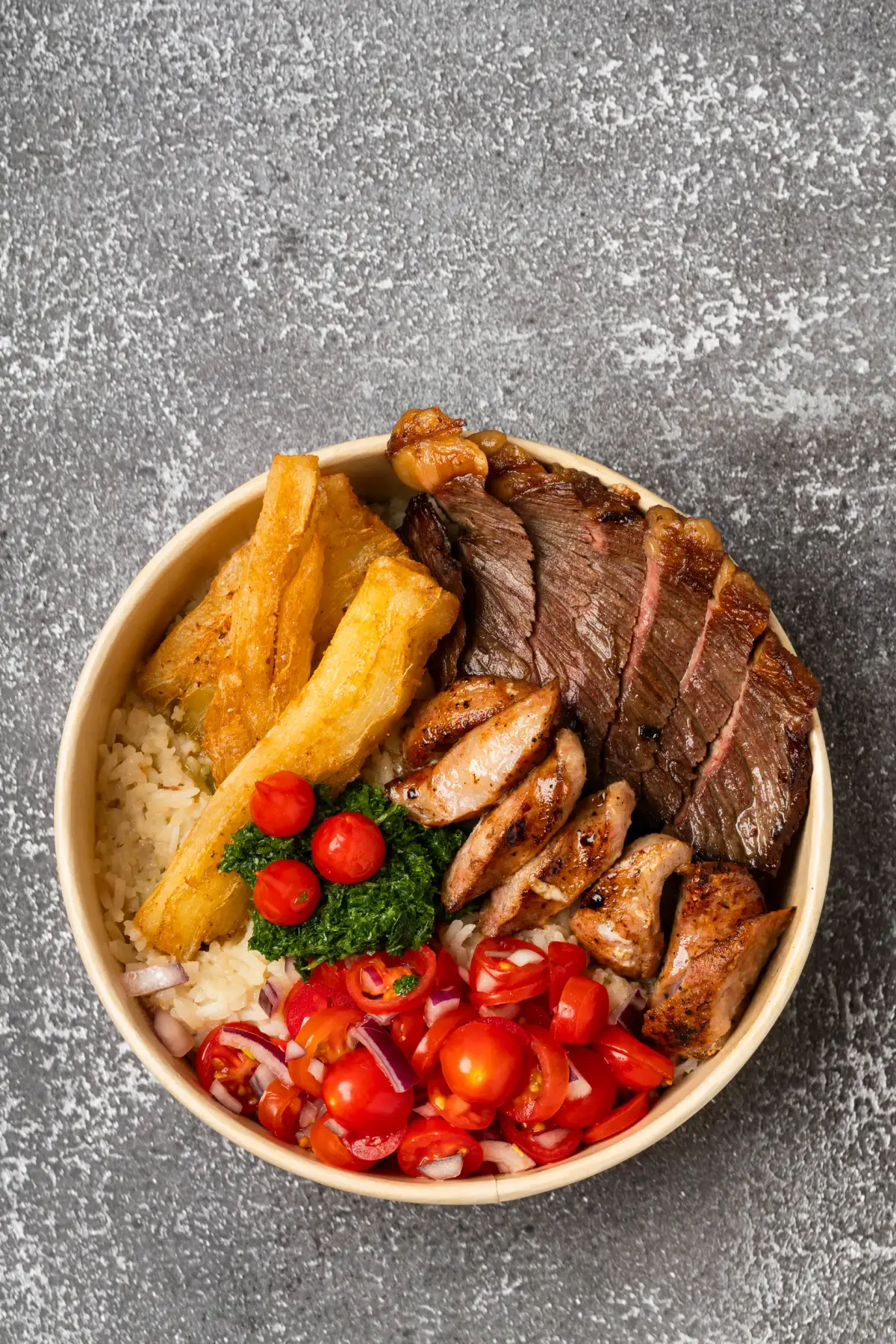 Overhead view of Uai Mate BBQ carreteiro plate with sliced steak, sausages, cassava, chimichurri, and tomato salsa on rice