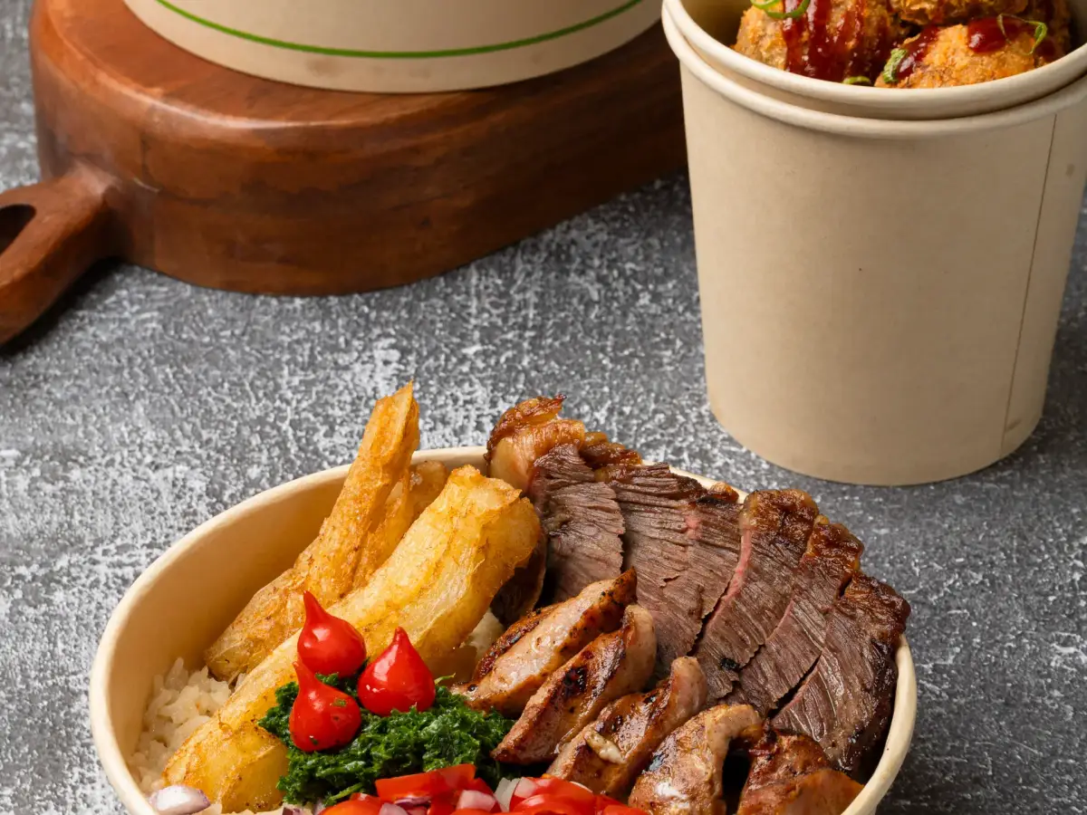 Uai Mate Brazilian street food lineup featuring loaded fries, croquete cup, and BBQ carreteiro bowl on grey background